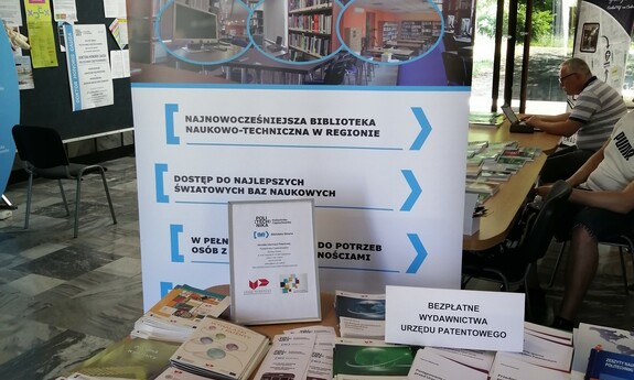 Baner Biblioteki Głównej a przed nim ułożone wydawnictwa Urzędu Patentowego.