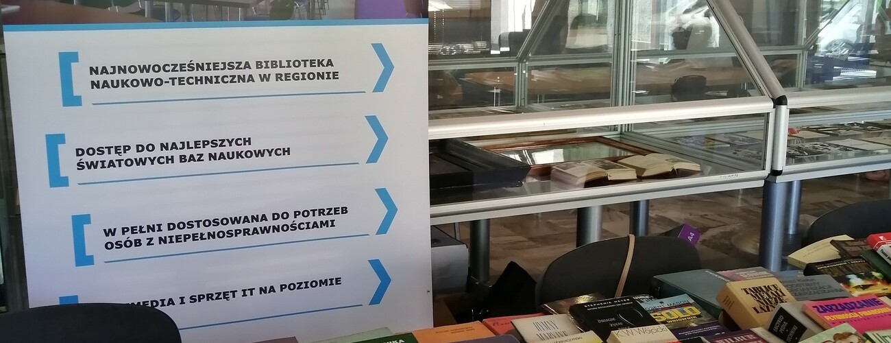 Stoisko Biblioteki Głównej Politechniki Częstochowskiej na tle baneru informacyjnego.